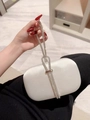 Detailed view of white satin clutch bag with elegant sparkling rhinestone knot handle - Silver