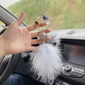 Car charm detail showing a tree of life design with colorful stones and white feathers - Gray