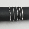Dettaglio dei bracciali a catena Figaro e paperclip in argento su espositore nero - Set di 5 / Stile 2 Argento