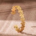 Macro shot of gold floral bangle with brushed metal texture and 18K gold finish - Flower