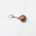 Close-up of brown metal pet bell with silver lobster clasp on white background - Painted Coffee