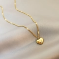 Elegant gold heart necklace with Love engraving on textured soft background - Gold