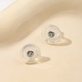 Macro detail of 18K gold and silicone butterfly earring backs for DIY jewelry making - White Gold