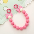 Detail view of pink and cream acrylic beaded strap with bow accents and metal spring buckles - Rose Red