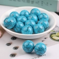 Polished blue turquoise stone sphere ornaments with black mesh textures in a bowl - Turquoise