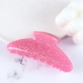 Pink glitter acrylic shark hair clip for women shown on a marble background - Barbie Pink
