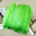 Detail of natural green goose feathers for DIY crafts on a rustic woven mat background - Stiff Fruit Green (50Pcs)
