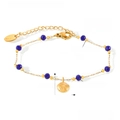 Detail eines Goldarmbands aus Titanstahl mit blauen Kristallperlen und Muschelanhänger - Goldenes Armband (TXE075)