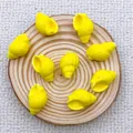 Macro shot of bright yellow conch shell beads for DIY jewelry making on wooden background - Yellow