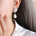 Elegant silver drop earrings with round and teardrop pearls worn by a model - F908 Steel Color Earrings