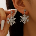 Elegant silver snowflake earrings with white pearls and rhinestones on model's ear - Silver Snowflake Long Drop Earrings Style (8583)