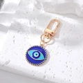 Detail of blue evil eye keychain with gold twisted frame on white stone plate - 4# Spiral Pattern Round Eye
