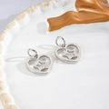 Macro shot of silver heart and star hollow charms on a white ceramic plate for DIY jewelry - Heart Star Silver