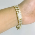 Dettaglio di un bracciale a catena cubana dorata con strass scintillanti sul polso - Bracciale Oro 20cm
