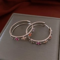 Close-up of silver hoop earrings featuring colorful zircon flowers on a textured dark base - 23# Silver Brushed Texture Zircon Flower Hoop