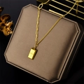 Collier avec pendentif lingot d'or et gravure GOLD sur un écrin à bijoux marron - Brique d'Or Riche / Doré