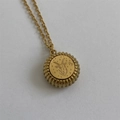 Detail of gold Capricorn zodiac medallion pendant with intricate circular engraving - Capricorn