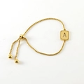 Pulsera ajustable de acero inoxidable dorado con un dije cuadrado y la letra A calada - Letra A / Dorado
