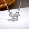 Silver bowknot tassel necklace with sparkling crystals shown in a macro view - XL235 Necklace / White Gold
