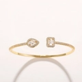 Macro-opname van een gouden verstelbare armband met druppelvormige en rechthoekige zirkonia - Goud Wit
