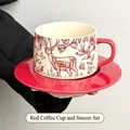 Red ceramic coffee cup and saucer set featuring hand-drawn deer and floral patterns - Floral Deer / Red