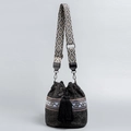 Handwoven black straw bucket bag featuring a bohemian patterned strap and tassel closure - Black