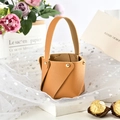Close-up of a brown PU leather bucket gift bag with gold rivets for wedding favors - Khaki (Pack of 10)