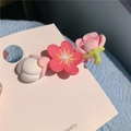 Sweet matte pink and white floral hair clip on a pink card held by a hand - D-017 Pink Stamen