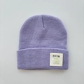 Detail of lavender knitted beanie featuring a cute bear patch and ribbed wool texture - One Size (Ages 3+) / Purple