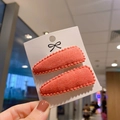 Close-up of coral red plush waterdrop hair clips with small ball edge trim in a set of two - Coral