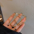 Close-up of golden heart-shaped hoop earrings featuring a unique twisted metal texture - E4983 Gold Twisted Hearts