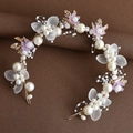 Macro detail of handmade bridal headband with gold leaves, white pearls and purple flowers - Purple