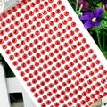 Close-up of a sheet of 3mm red round acrylic crystal stickers for DIY crafts - 6mm / Red