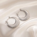 Detail shot of silver earrings with spiral wave texture on a cream silk background - Round Diagonal Texture Hoop (0237)
