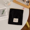 Close-up of black fabric makeup pouch with yellow zipper and colorful letter label - Black (Vertical)