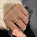 Close-up of gold clover ring with sparkling crystals worn with a knit sweater - Adjustable / Gold Clover Ring