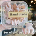 Detalle de un juego de 10 mini pinzas para el cabello rosa mate en una caja transparente - 10 Unidades/Caja / Rosa nude