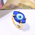 Makroaufnahme eines verstellbaren Goldrings mit blauem Glas-Auge und feinen Details - Einstellbar Offen / Dunkelblau