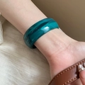 Macro detail of wide marbled green acrylic bangle worn on wrist with leather strap - 11# Dark Blue