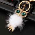 Detailed close-up of owl keychain with white faux fur pompom and green gemstone eyes - Plush Owl White