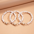Dreiteiliges Set eleganter Acrylperlenarmbänder mit goldenen Blumenanhängern - Weißes Blumen 3er-Set (HB4308)