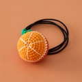 Close-up of handmade crochet orange hair tie with elastic band for girls - Round Orange