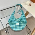 Detail of blue and green plaid canvas hobo bag texture with a minimalist white logo patch - Blue Green Grid