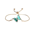 Detail view of adjustable gold-tone bracelet with green crystal butterfly and slider clasp - Green