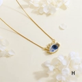 Detailed close-up of a gold-plated evil eye pendant with blue resin and zircon accents - Blue - Gold Box Chain