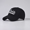 Detailed close-up of white Brkln script embroidery on a black cotton baseball cap - Black