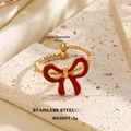 Golden stainless steel ring featuring red enamel bow with textured band detail - Red Enamel Bow Style (1461)