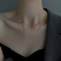 Minimalist gold double layer choker necklace with round beads on model against grey wall - Double Layer Necklace / Gold