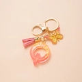 Letter Q resin keychain with pink tassel, golden butterfly charm and glitter finish - Letter Q