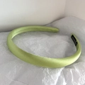 Detail of light green satin headband with handmade label on white textured background - Light Green